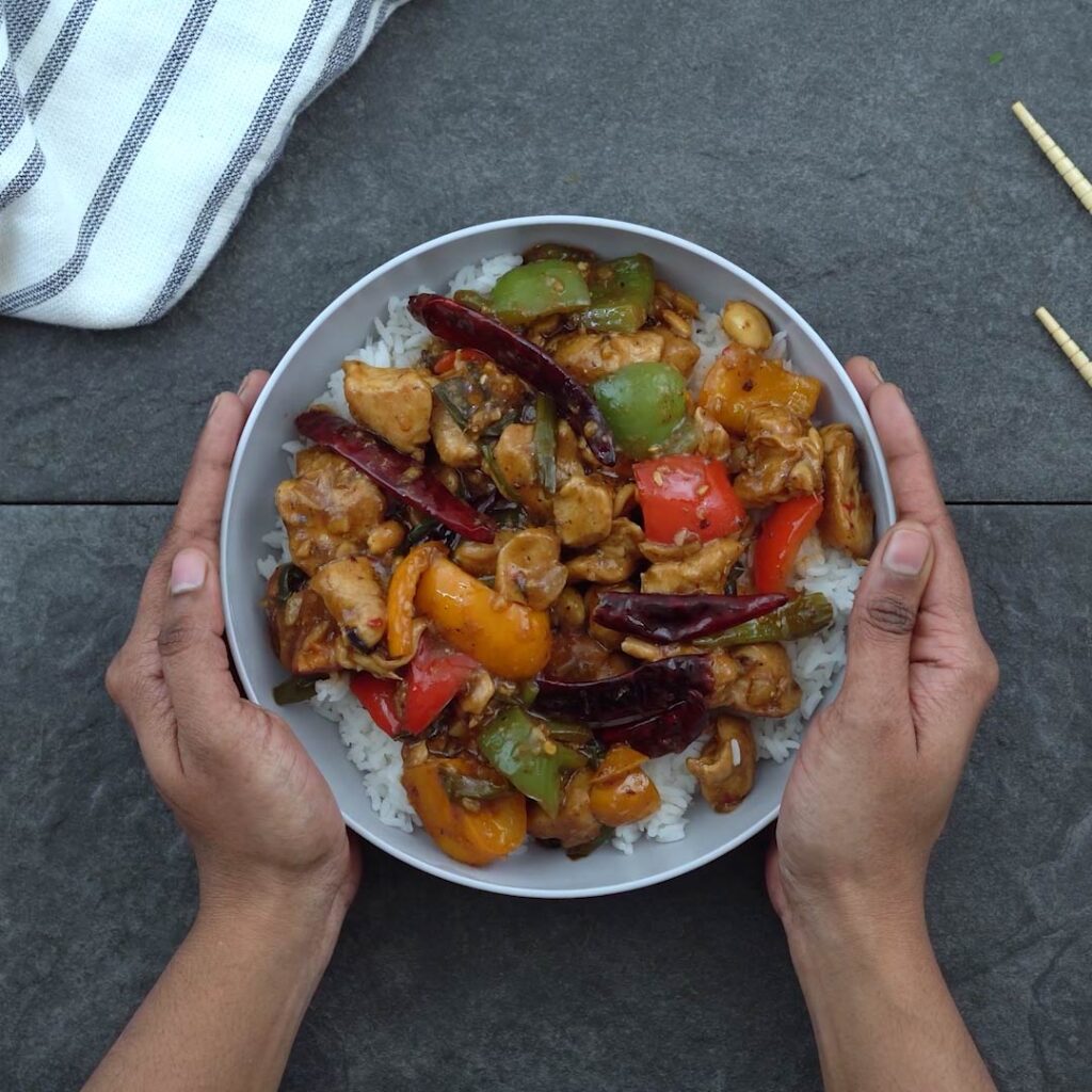 serving authentic Kung Pao Chicken in a serving bowl with rice