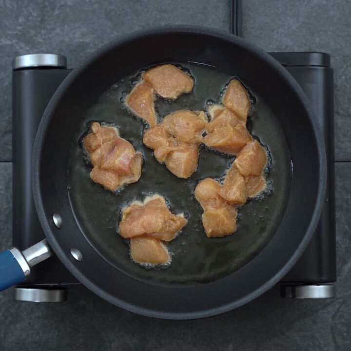 chicken is frying in a pan