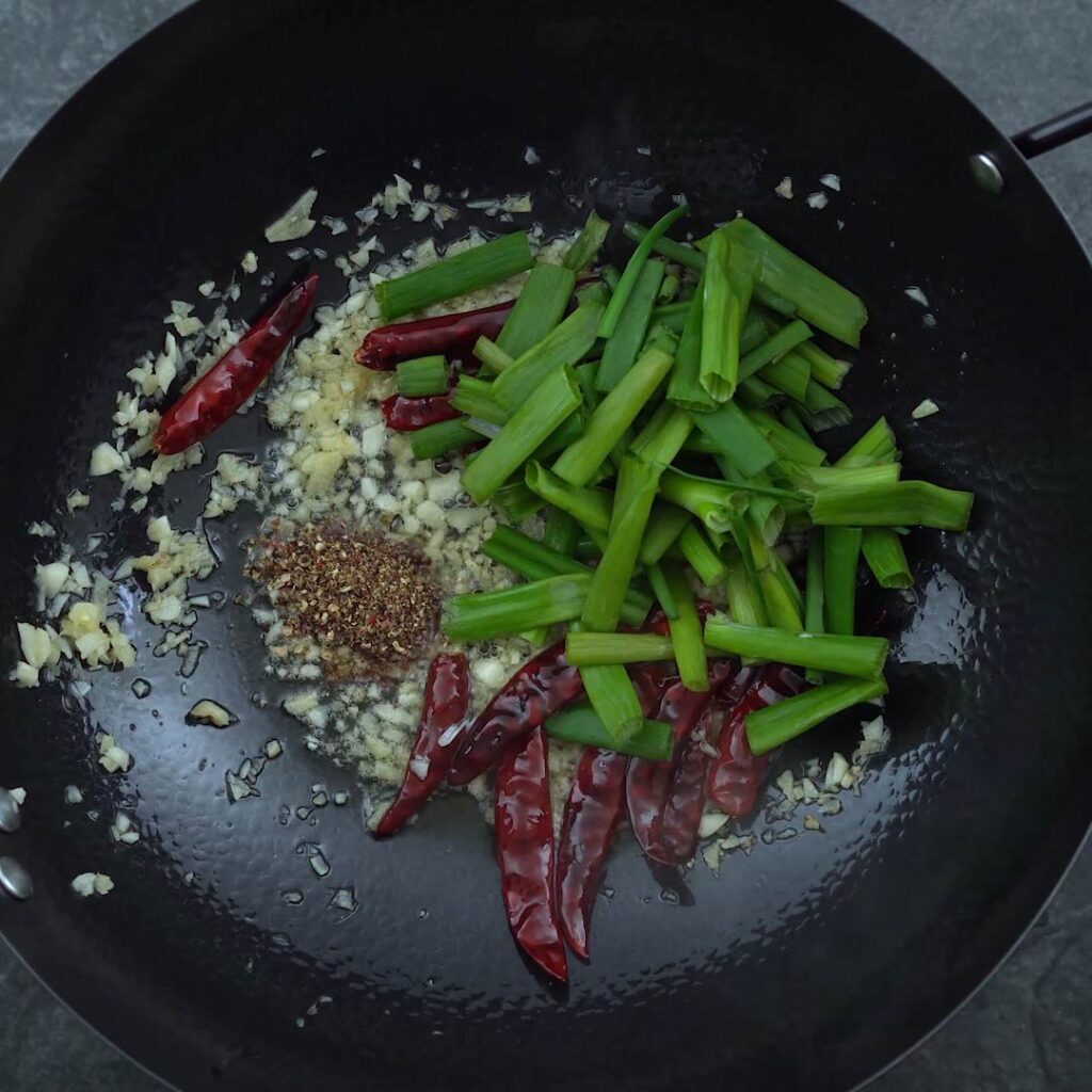 stir frying the Sichuan peppers and scallions