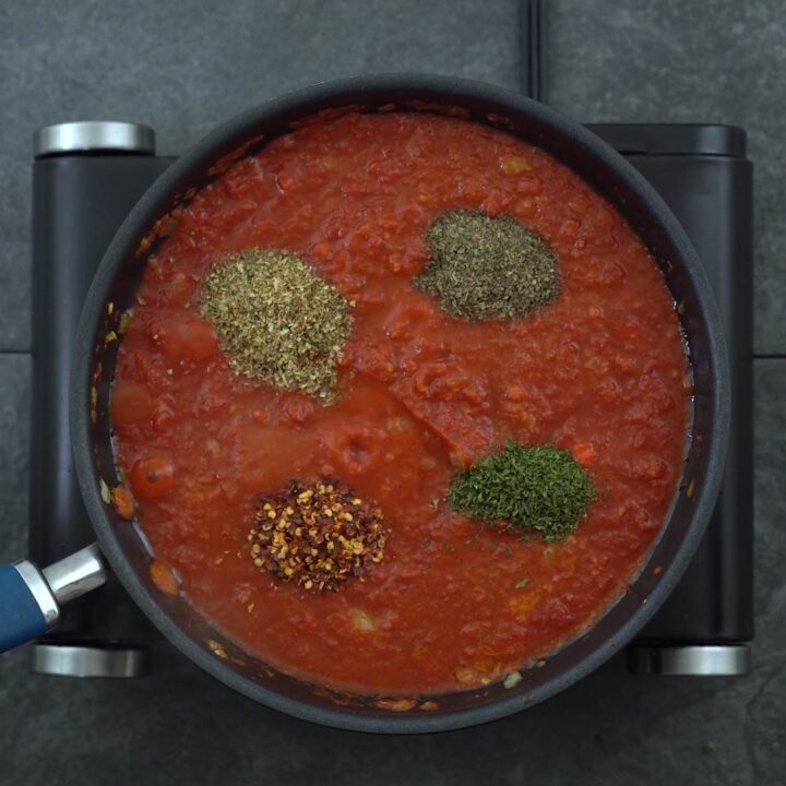 Tdried Italian herbs added to tomato sauce