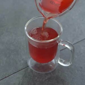 Pouring ginger tea to serving glass.