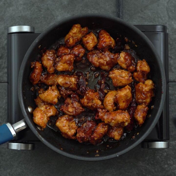 fried chicken is tossed into General Tso Sauce