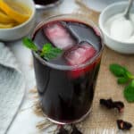 Hibiscus tea (Agua de Jamaica) served in a glass with ice cubes and mint leaves.