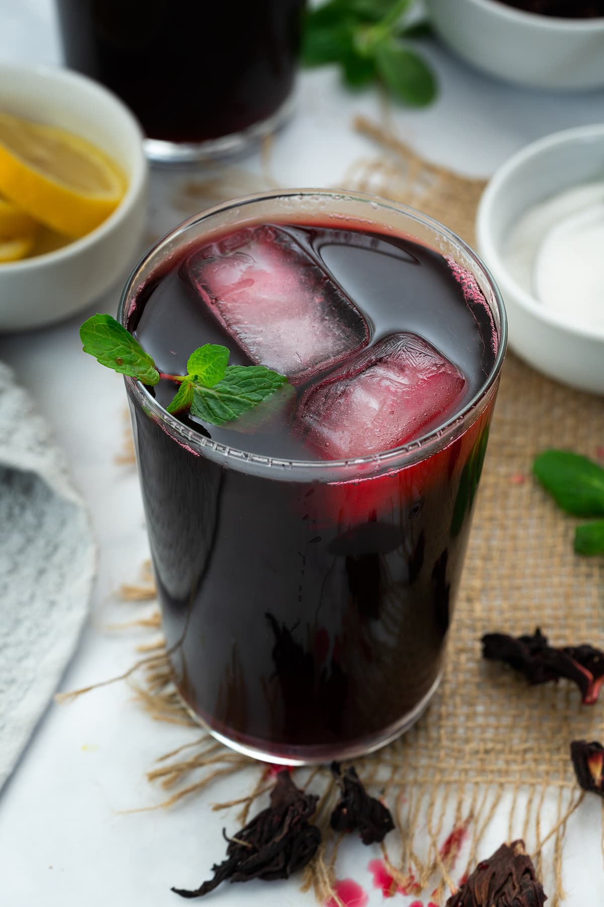 Hibiscus tea (Agua de Jamaica) served in a glass with ice cubes and mint leaves.