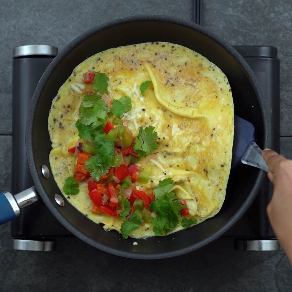 folding the veggie stuffed Omelette in half