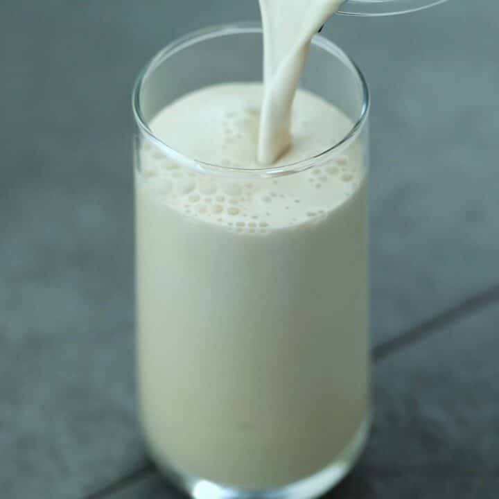 Pouring the iced coffee protein shake into a glass.