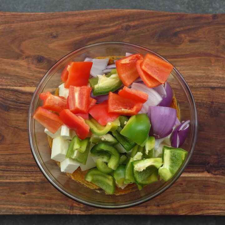 paneer and veggies in a glass bowl with marinade