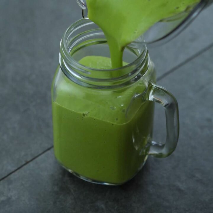 Pouring avocado smoothie into serving mug.