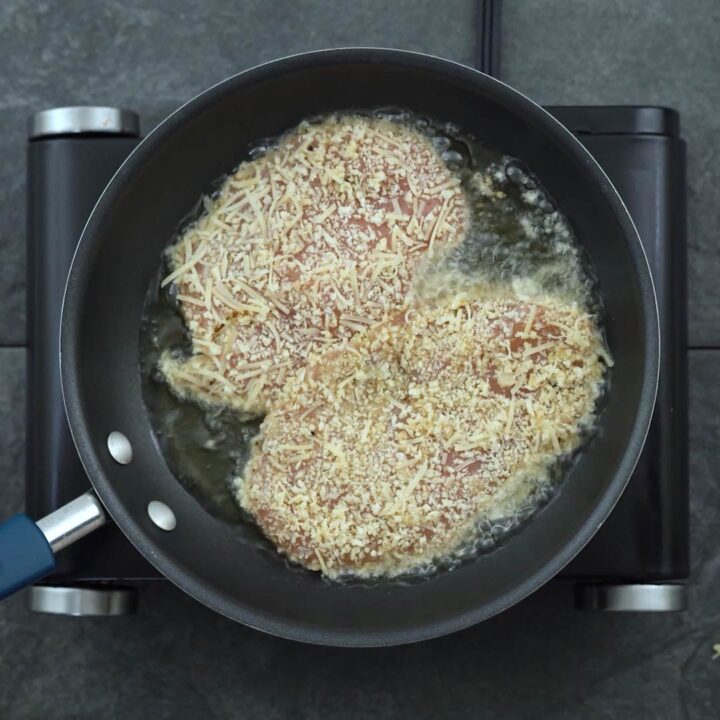 chicken cutlet frying in a pan