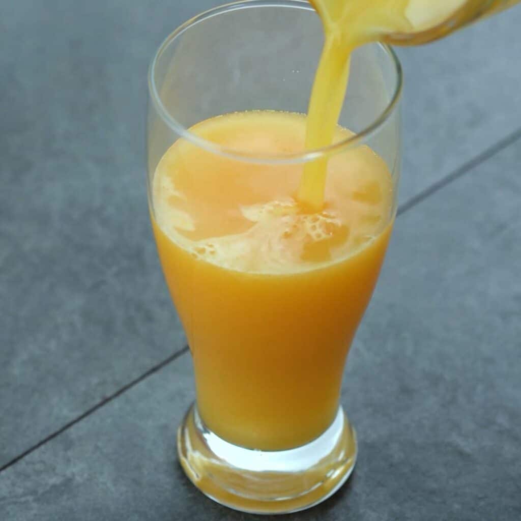 Pouring Orange Juice into glass.