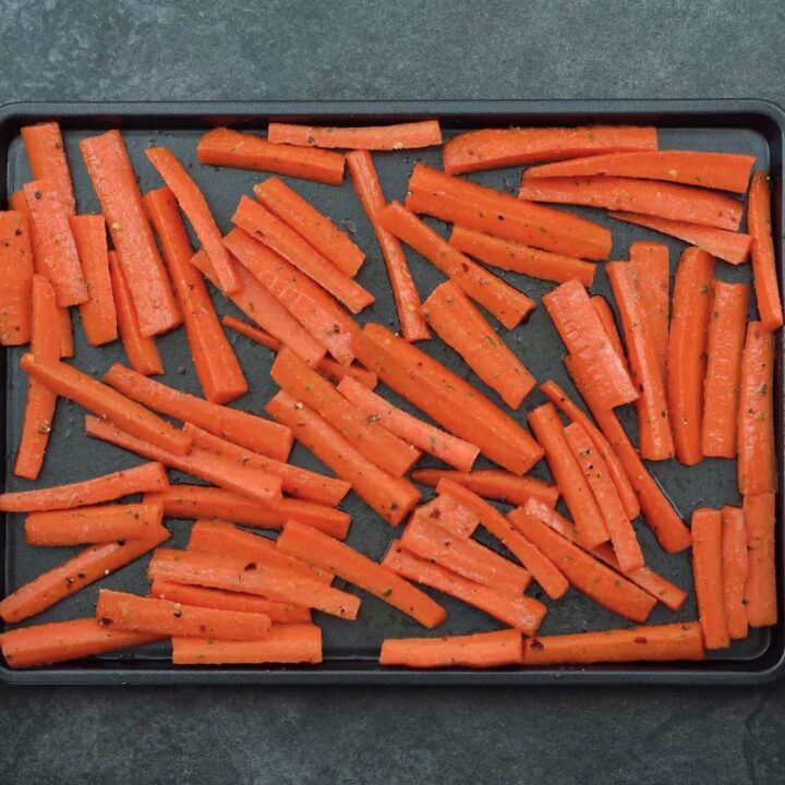 seasoned carrots transferred to baking sheet