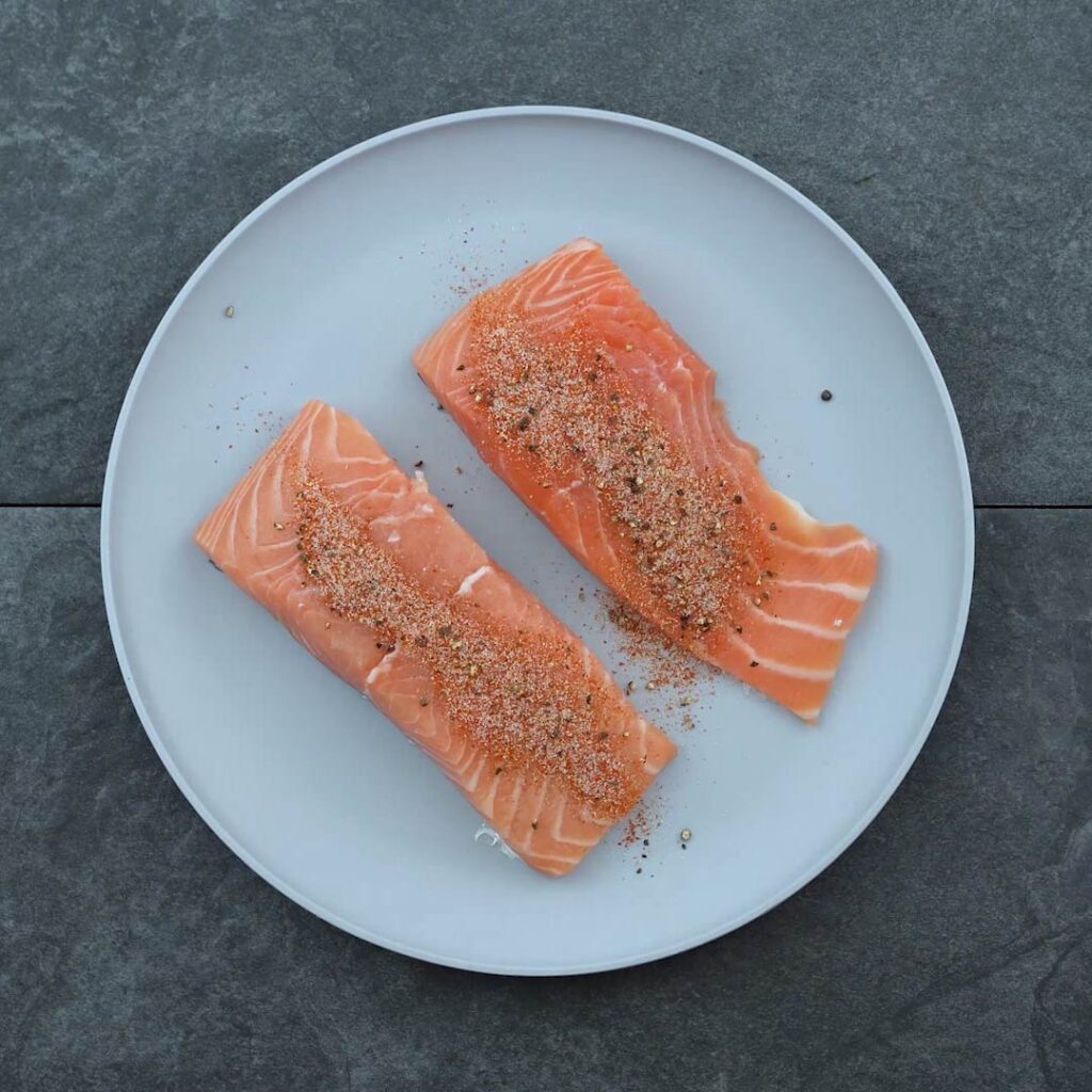 Salmon fillets with seasoning on a plate