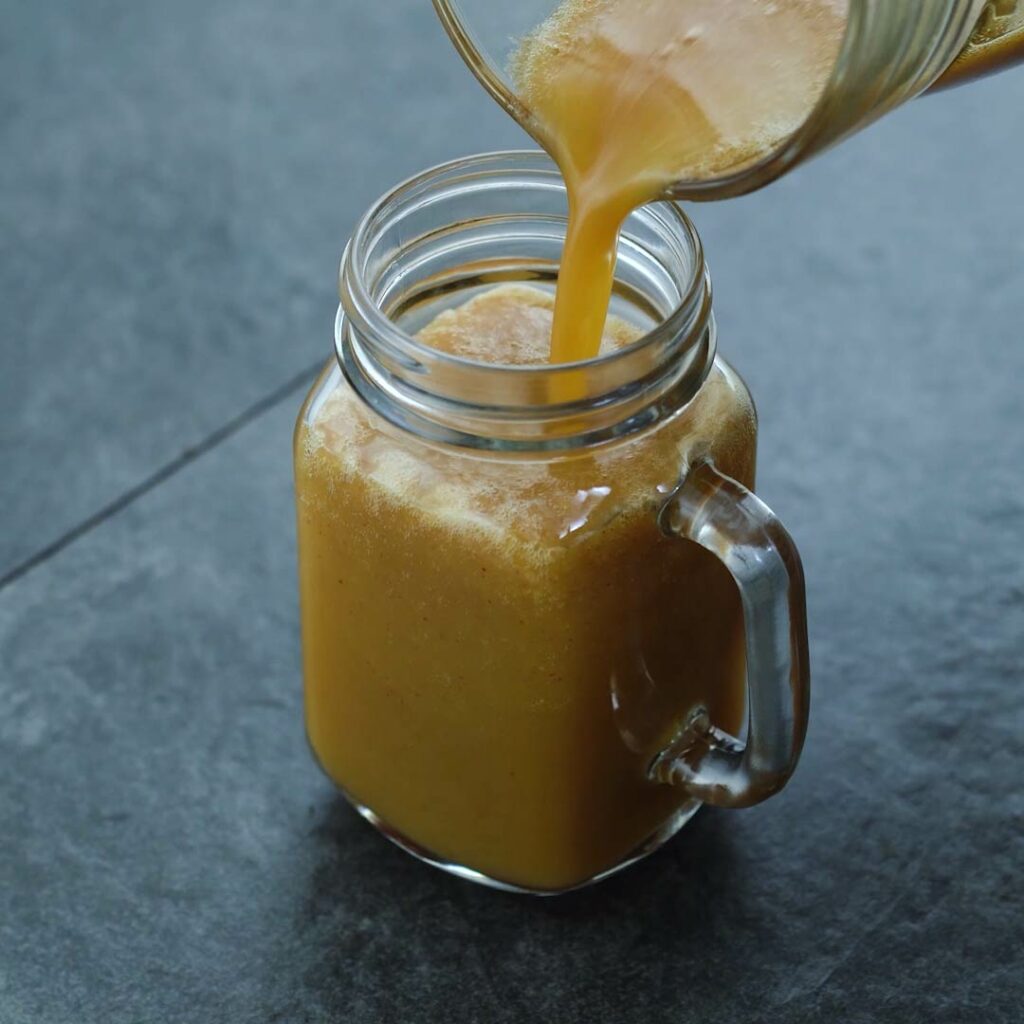 Pouring Apple Juice into a serving mug.