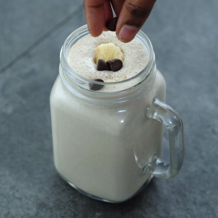 Topping the smoothie with banana and chocolate chip.