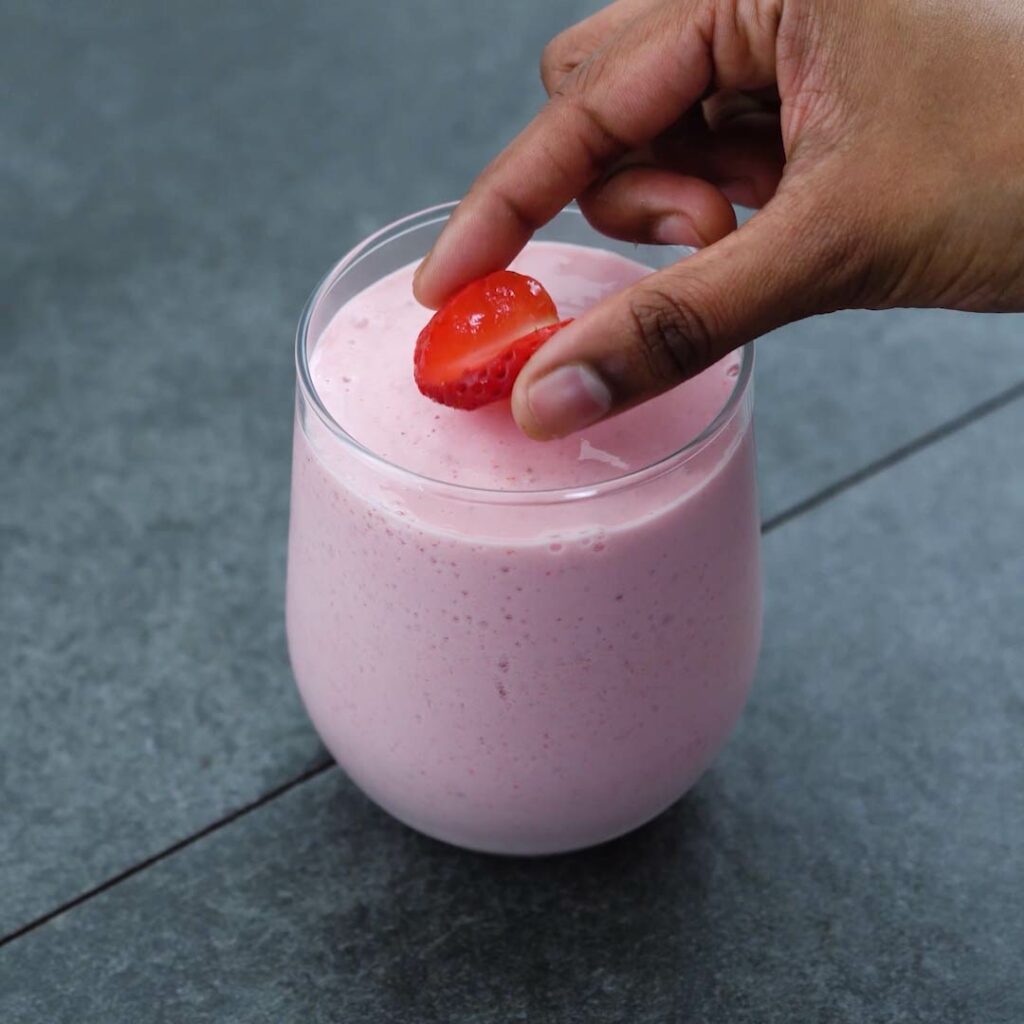 Topping Strawberry smoothie with strawberry slice.