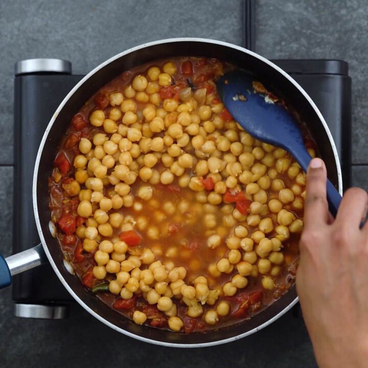 Stirring the cooked chickpeas to onion tomato mixture