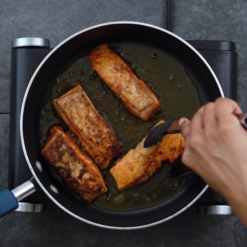 Flipping the salmon to fry