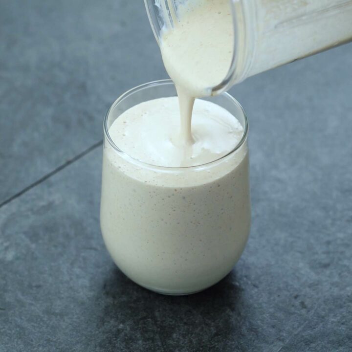 Pouring Oatmeal Smoothie into a serving glass.