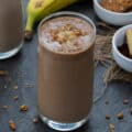Protein Smoothie served in a glass topped with banana and granola.