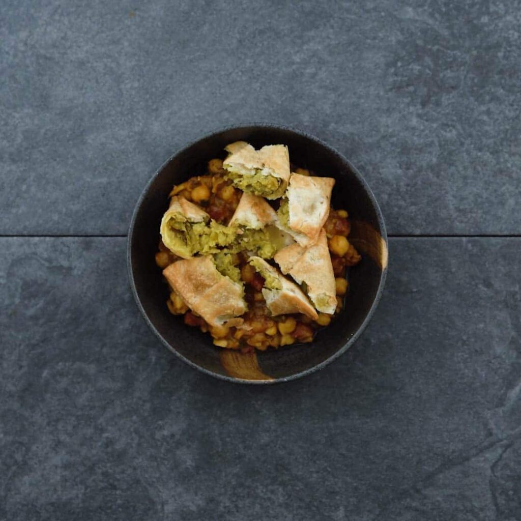 Samosa and chole in a serving bowl