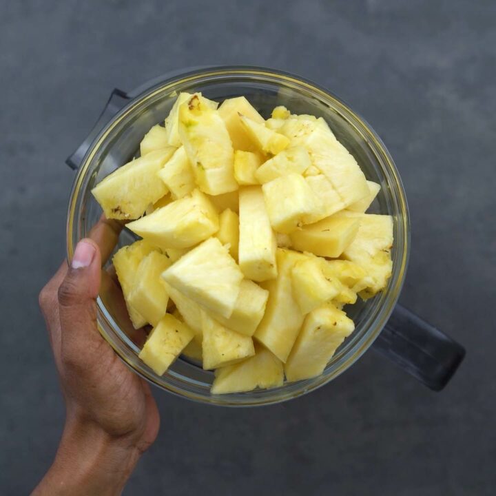 Adding chopped pineapple into jar.