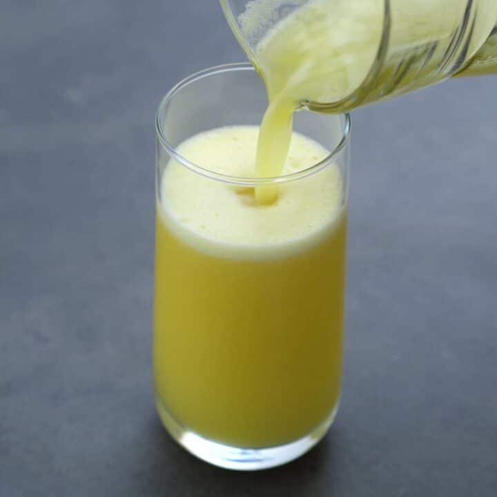 Pouring Pineapple Juice into a serving a glass.