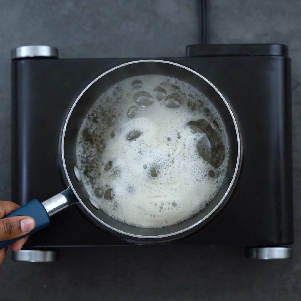 Sugar syrup boiling in a saucepan.