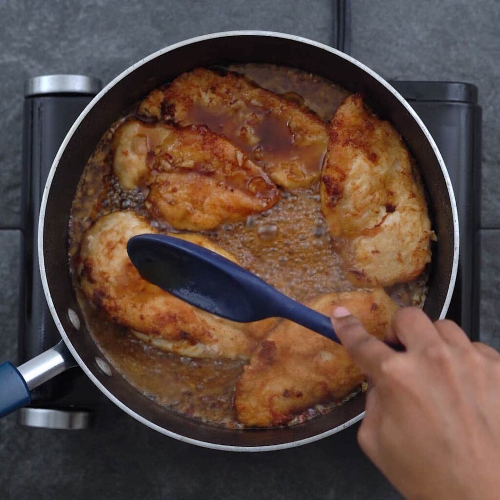 Coating chicken breast with honey garlic sauce