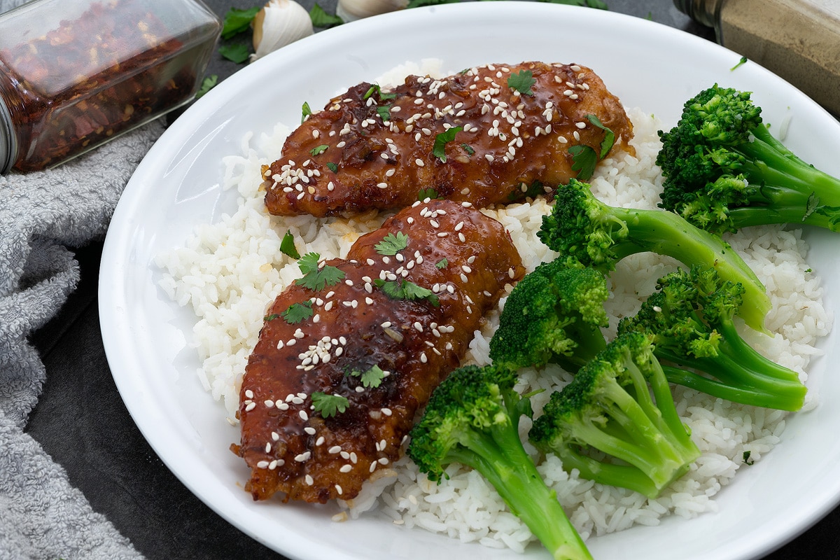 Honey Garlic Chicken Breast in a white plate with rice and broccoli
