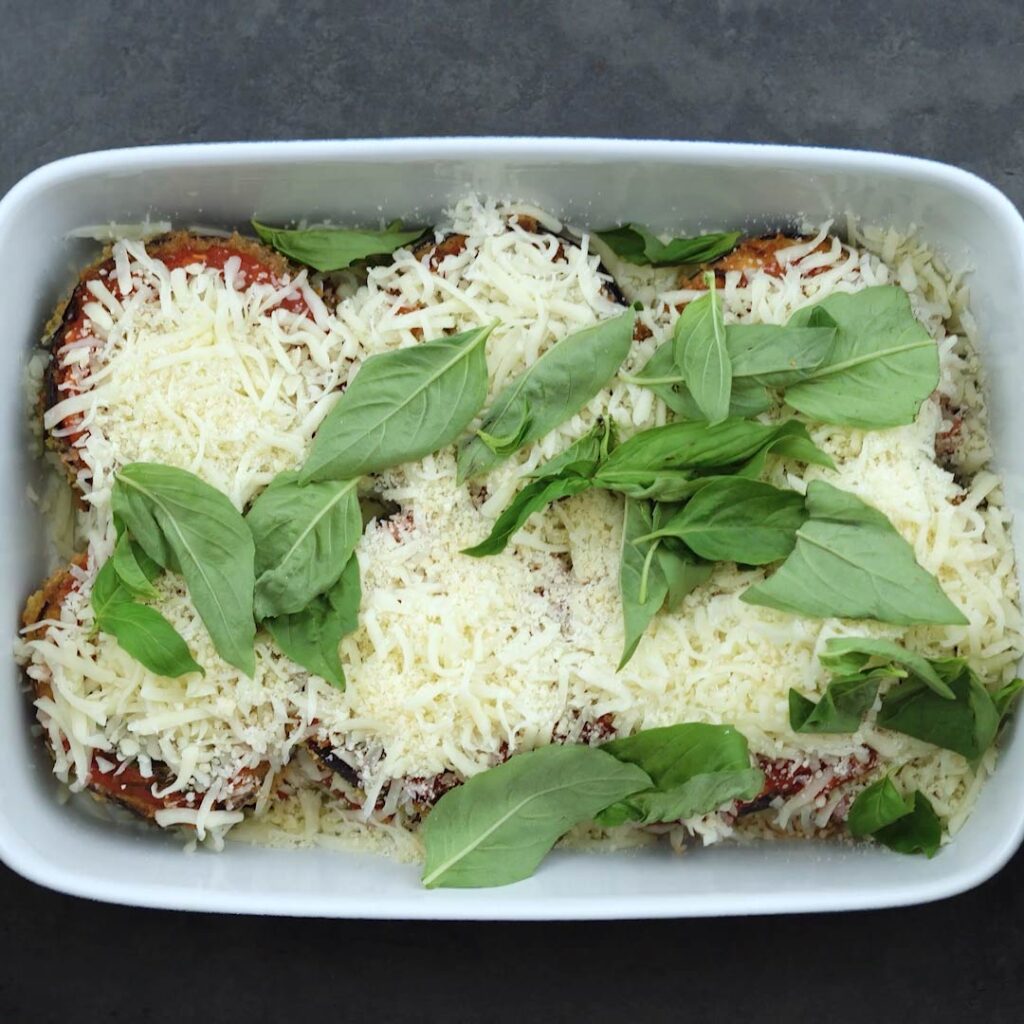 Eggplants garnished with parmesan and basil leaves
