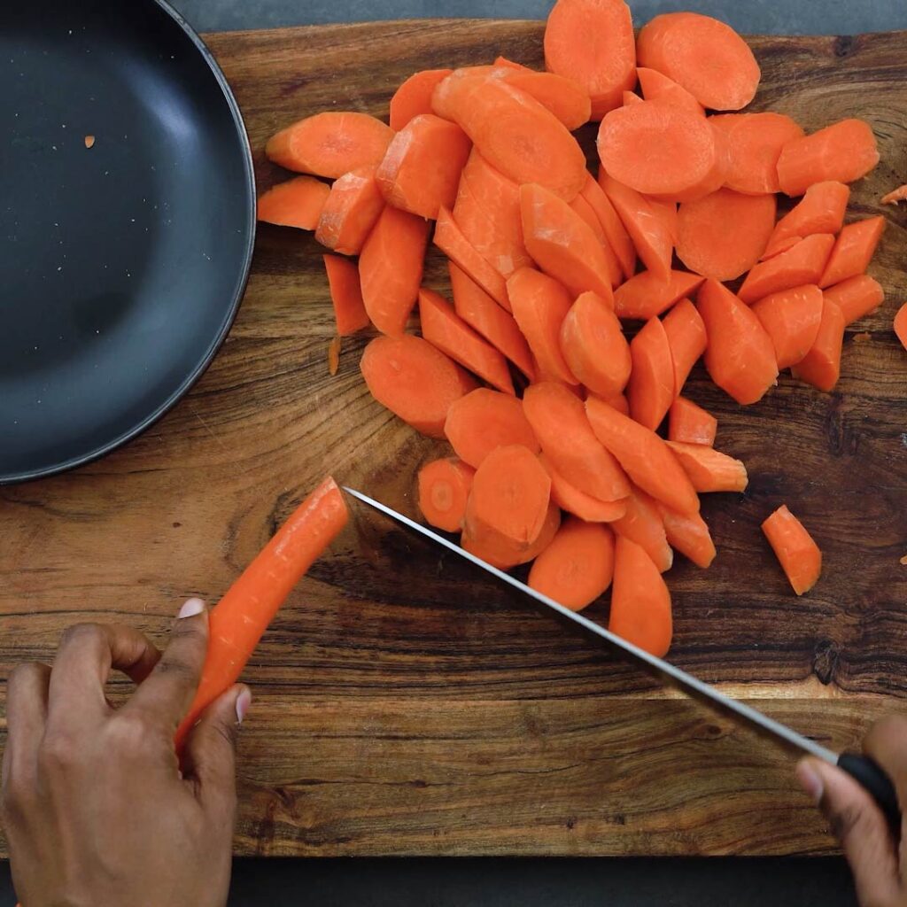 Chopping carrots diagonally on a cutting board