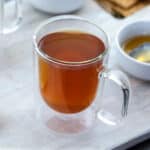 Honey and Lemon Tea in a cup placed on a white table.