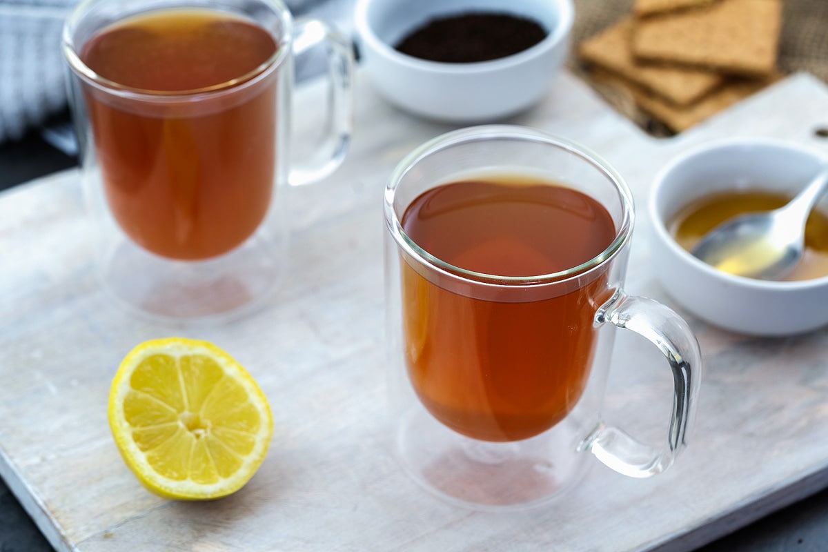 Honey and Lemon Tea in a cup placed on a white table.