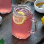 Pink Lemonade in a serving mug. Honey and lemon placed nearby.