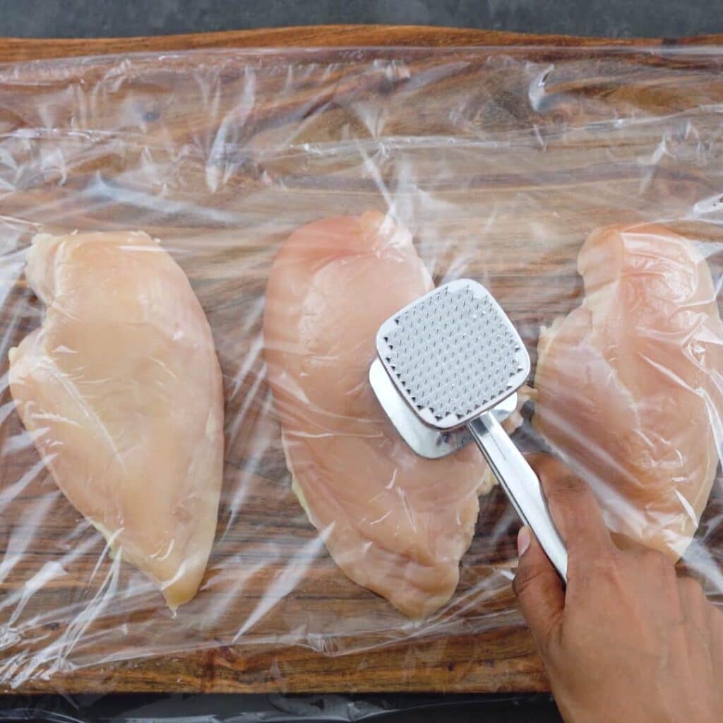 Pounding chicken breast with meat tenderizer