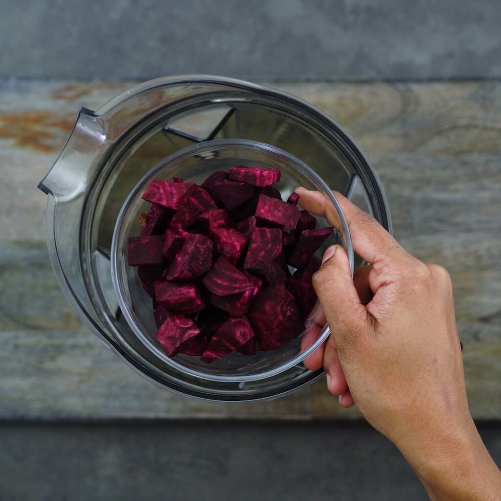 Adding beets to the blender jar.