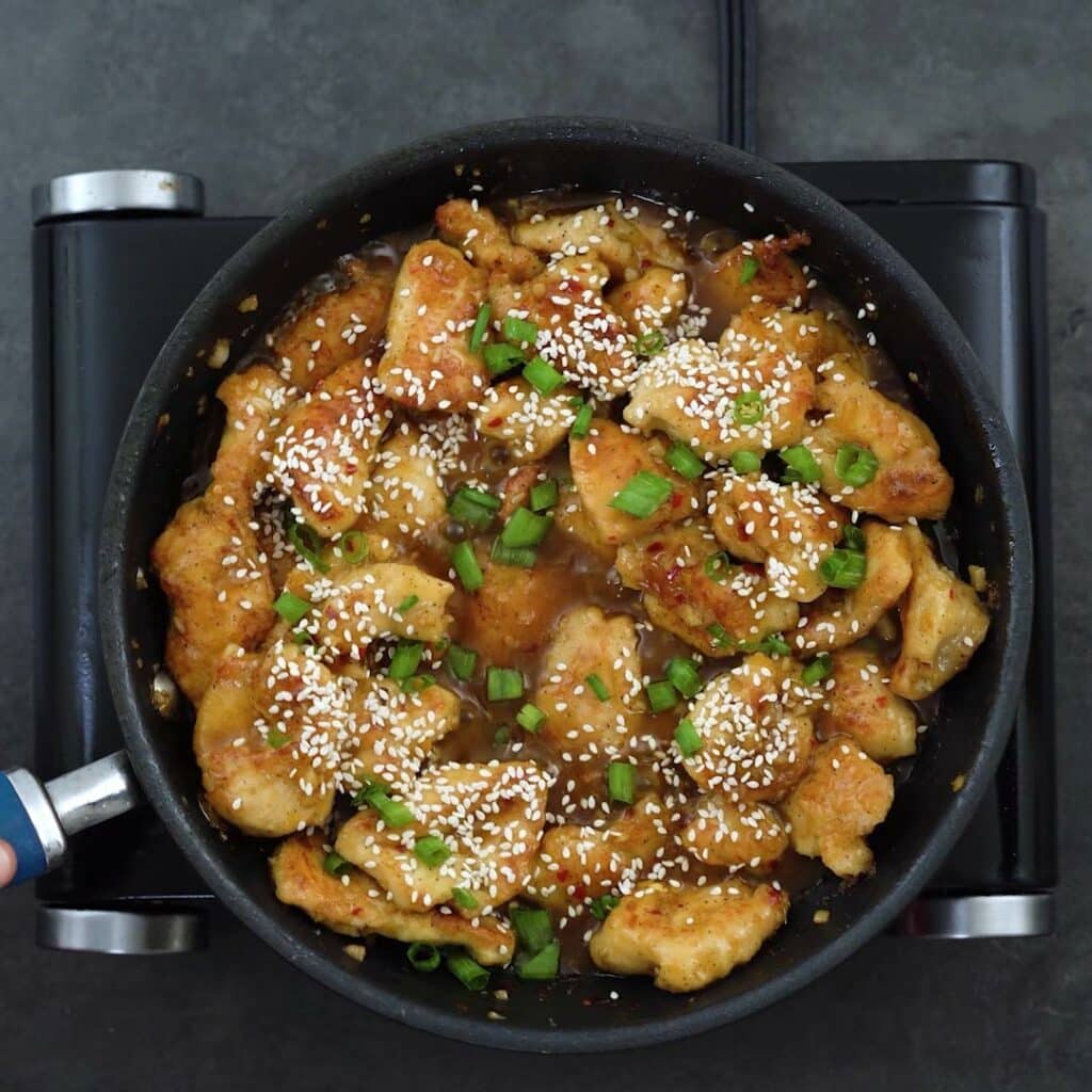 Orange Chicken garnished with sesame seeds and green onions