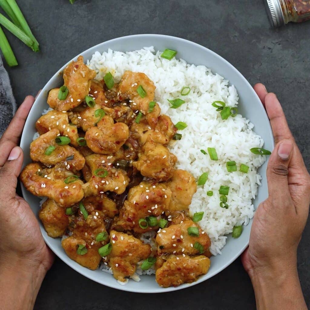 Serving Orange Chicken over rice in a bowl