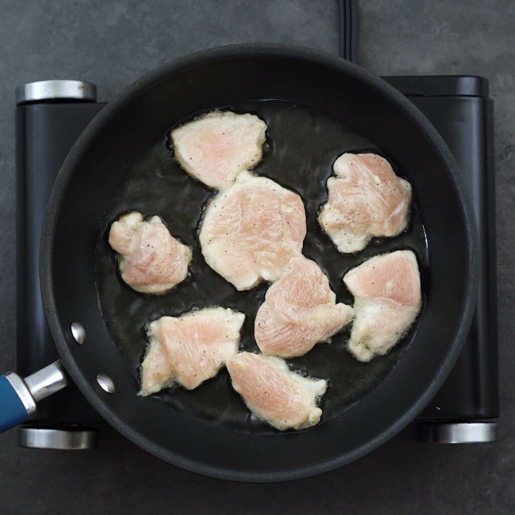 chicken breast frying in a oil
