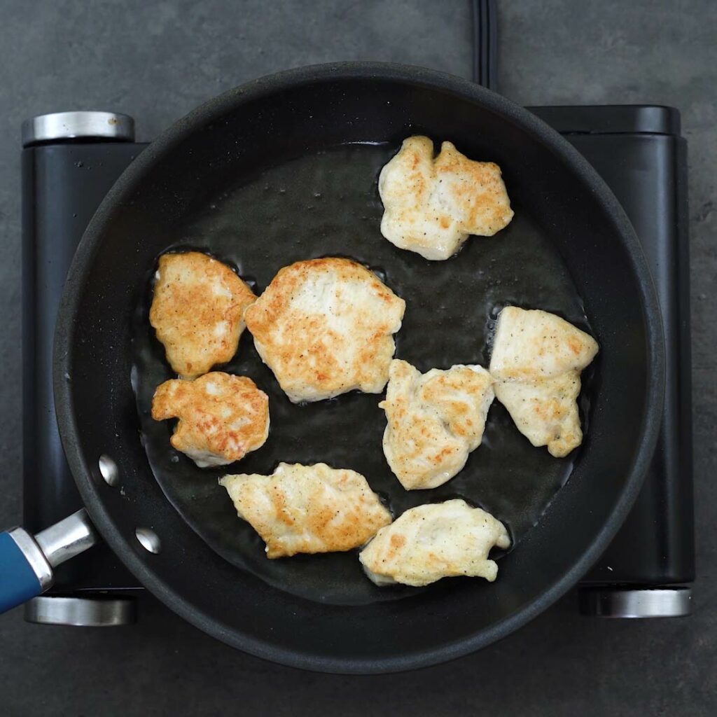 Golden fried chicken breast in a pan