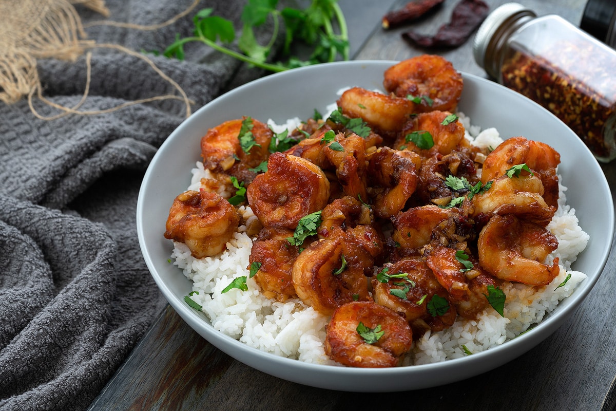 Honey Garlic Shrimp in a white bowl placed on a grey table