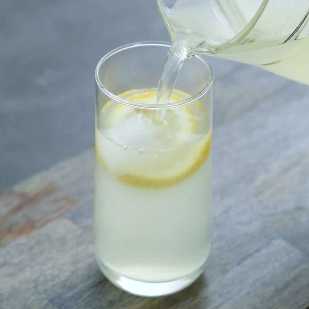 Pouring Lemon juice in a serving glass.