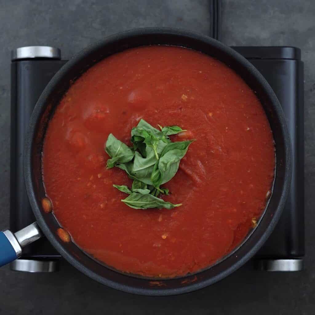 Marinara sauce with basil leaves in a pan