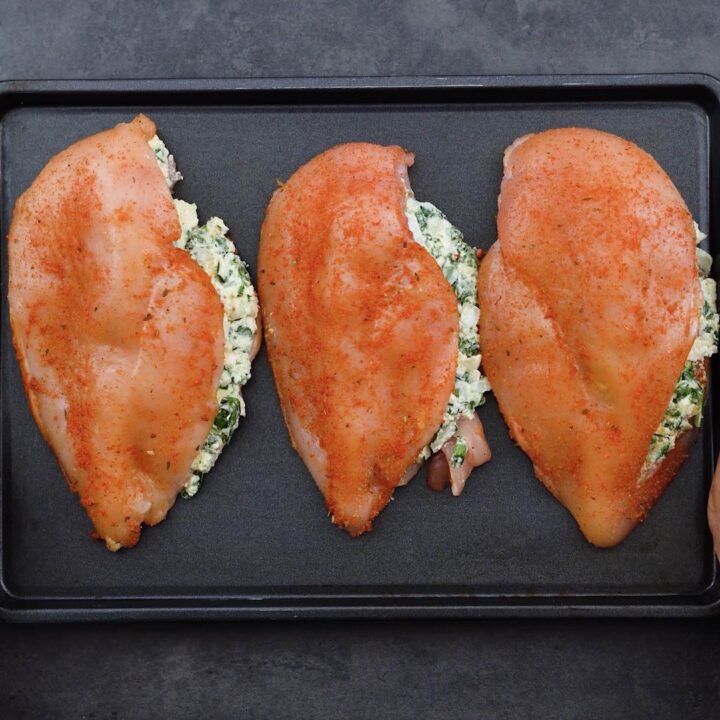 Spinach stuffed chicken breast on a baking tray