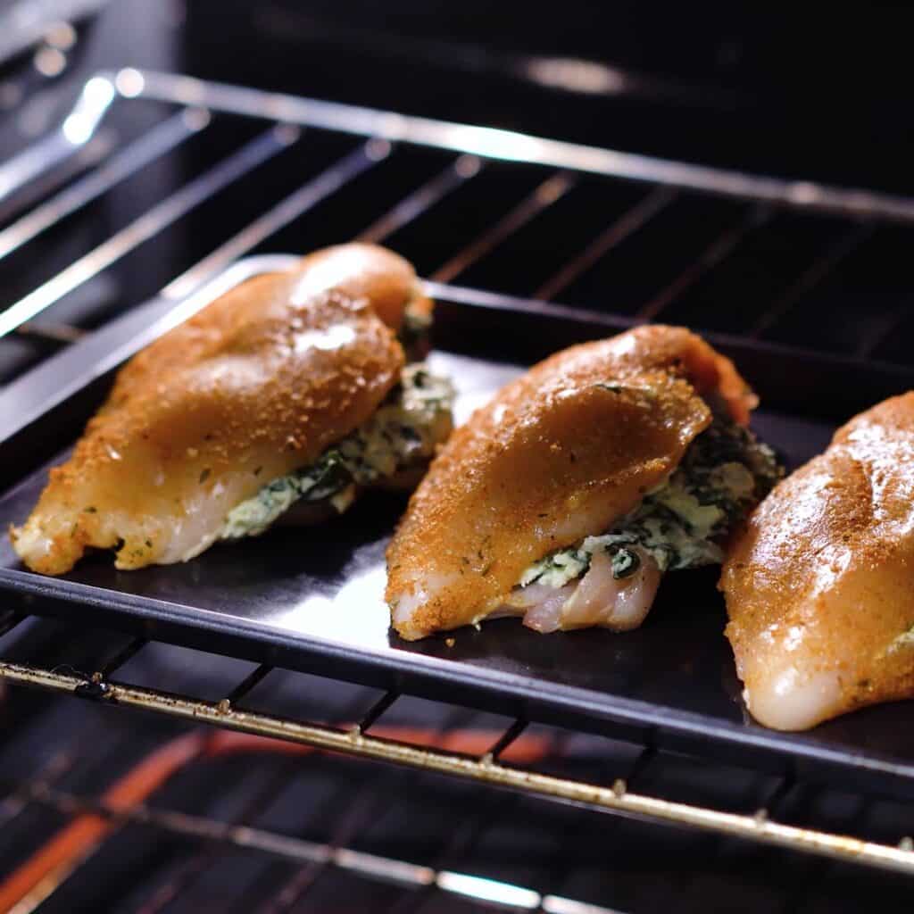Spinach stuffed chicken breast baking in oven