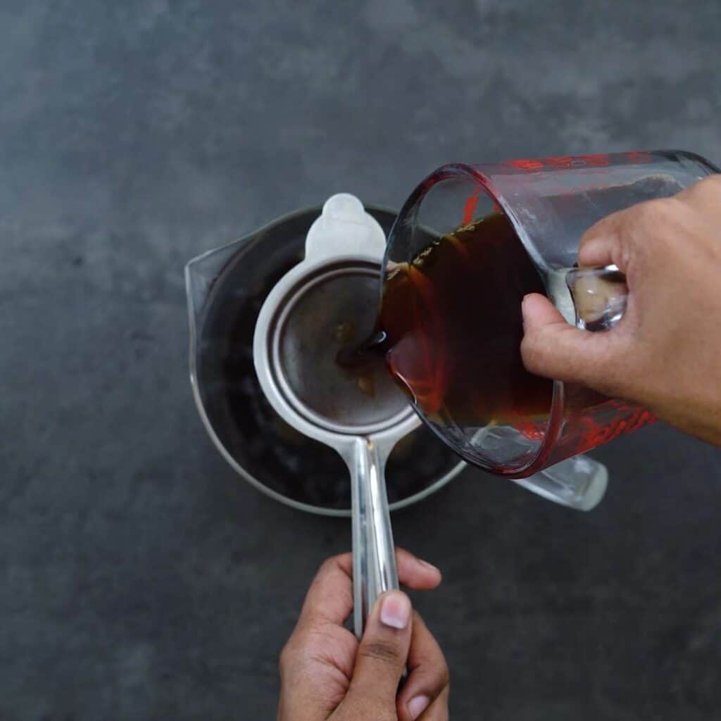 Filtering the tea into the pitcher.
