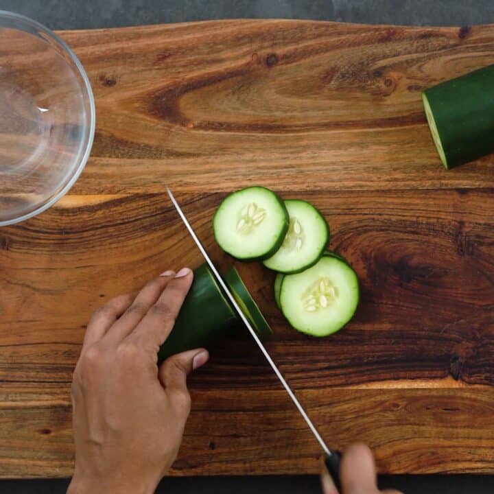 Slicing cucumber into circular shapes.