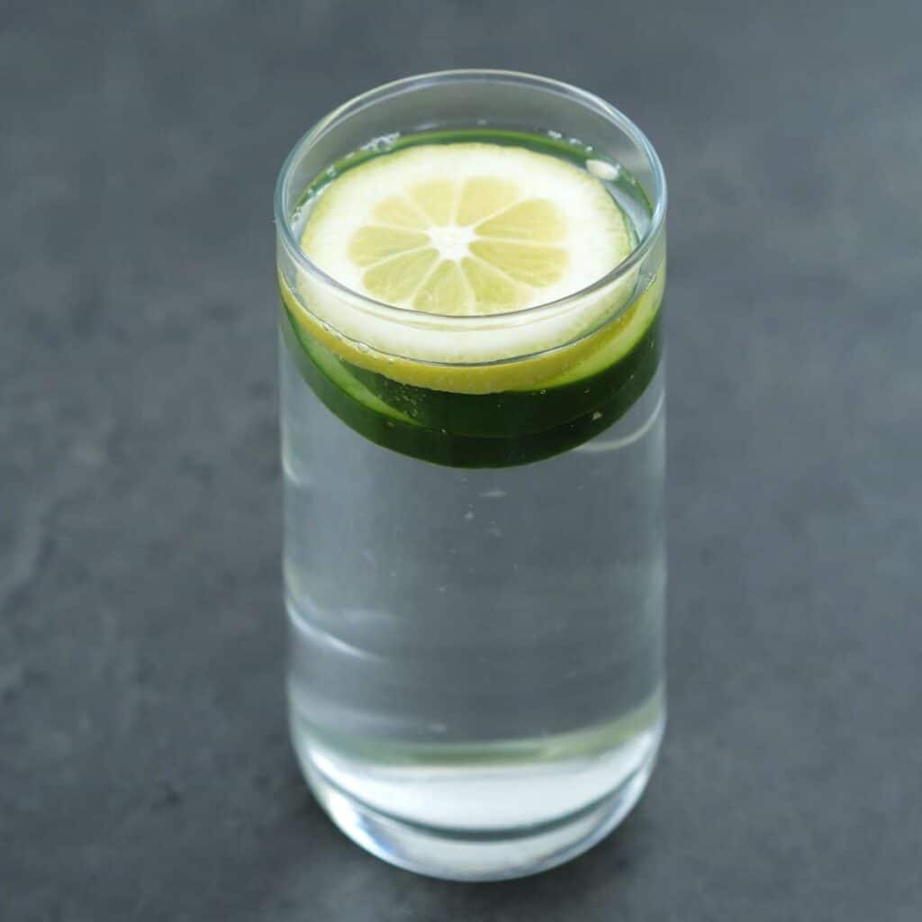 Cucumber Water in a serving glass with lemon and cucumber slice.