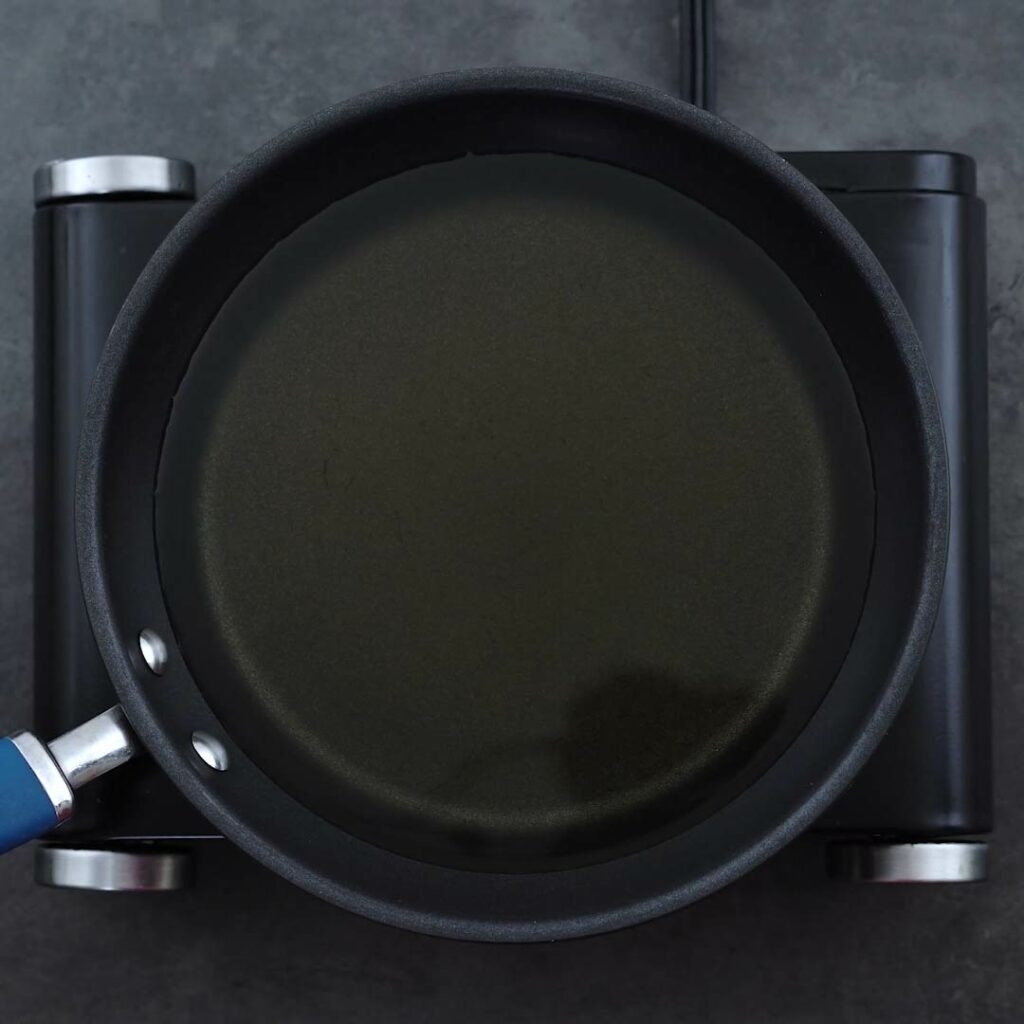 Oil heating in a deep frying pan.