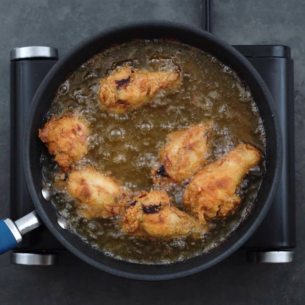 Golden brown Fried Chicken Wings frying in a Oil.